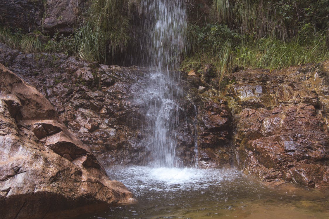 free-photo-of-waterfall-splashing-into-pond